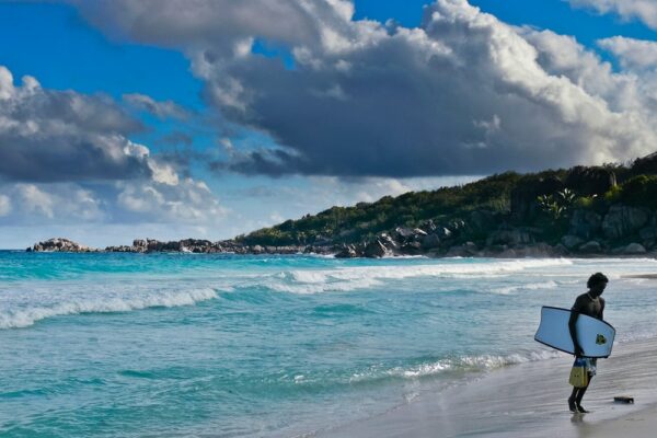 Surfer an der wilden Grande Anse, La Digue, Seychellen