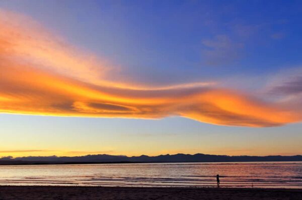 Anglerin unter UFO-Wolken, Tasmanisches Meer, Südinsel, Neuseeland