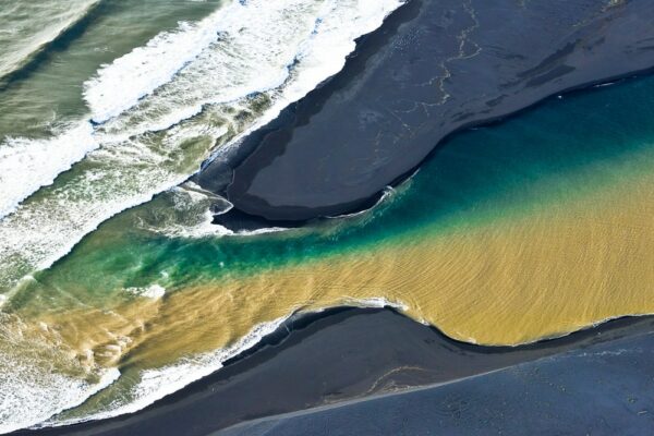 Zweifarbiger Fluss mündet in Atlantik, Luftbild, Island